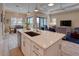 Bright kitchen featuring a spacious island with bar seating that flows into the living area with a view of the lanai at 6104 Talon Preserve Dr, Nokomis, FL 34275