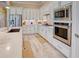Well-equipped kitchen featuring stainless steel appliances, white cabinetry, and tiled backsplash at 6104 Talon Preserve Dr, Nokomis, FL 34275