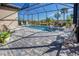 Relaxing screened-in pool area with lush landscaping, comfortable seating, and a serene water feature at 6104 Talon Preserve Dr, Nokomis, FL 34275