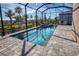 Inviting screened pool and spa surrounded by a brick patio and lush landscaping, creating a private outdoor oasis at 6104 Talon Preserve Dr, Nokomis, FL 34275