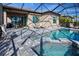 Inviting screened-in pool and spa with plenty of seating, a grill, and covered patio perfect for outdoor entertaining at 6104 Talon Preserve Dr, Nokomis, FL 34275