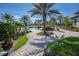 Manicured community garden walkway leading to the pool area with palm trees and lush landscaping at 6104 Talon Preserve Dr, Nokomis, FL 34275