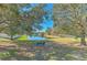 Scenic pond view with mature trees, a walking bridge, green space, and a bench for enjoying the outdoors at 6217 Evansbrook Dr, Zephyrhills, FL 33541