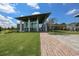 Modern clubhouse with a unique roof design, surrounded by lush green lawns and a brick pathway at 7010 Old Benton Dr, Apollo Beach, FL 33572