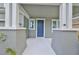 Inviting covered front porch with white columns and blue front door, great curb appeal at 7010 Old Benton Dr, Apollo Beach, FL 33572