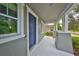 View of the light-filled front porch and blue front door of this inviting home at 7010 Old Benton Dr, Apollo Beach, FL 33572