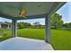 Covered patio overlooking backyard with green lawn and blue sky at 7010 Old Benton Dr, Apollo Beach, FL 33572