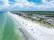 Sweeping aerial view of beachfront, homes, commercial buildings, and oceanfront landscape at 704 180Th E Ave, Redington Shores, FL 33708