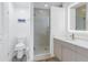 Bright bathroom with a glass-enclosed shower, modern vanity, and a large, illuminated mirror at 704 180Th E Ave, Redington Shores, FL 33708