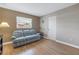 Cozy living room with a comfortable plaid couch, window, and laminate floors at 704 180Th E Ave, Redington Shores, FL 33708