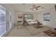 Bright living room with white sofa, textured rug, ceiling fan, and access to the pool at 7211 Bowspirit Pl, Apollo Beach, FL 33572