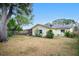 The home's backyard features mature trees, a well-maintained lawn, and a fence, providing a private outdoor space at 7281 61St N Ave, St Petersburg, FL 33709