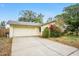 Single-Gathering home with a two-car garage, neutral paint, and mature landscaping at 7281 61St N Ave, St Petersburg, FL 33709