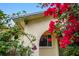 Charming home entrance with vibrant bougainvillea, house number, and stucco facade at 7281 61St N Ave, St Petersburg, FL 33709