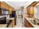 Well-lit kitchen with wood cabinets, black appliances, and decorative wallpaper at 7281 61St N Ave, St Petersburg, FL 33709