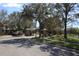 Community entrance with a security gate, mature trees, and well-maintained landscaping at 8010 Bally Money Rd, Tampa, FL 33610