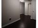 Hallway featuring wood-look floors, baseboards and neutral walls, complemented by natural lighting at 8010 Bally Money Rd, Tampa, FL 33610