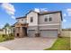 Two-story home featuring stone accents, a spacious three-car garage, and beautiful landscaping at 8161 Lago Mist Way, Wesley Chapel, FL 33545