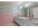 Retro bathroom with colorful swan wallpaper, pink tile, and dual sinks at 8468 Flagstone Dr, Tampa, FL 33615