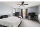 Well-lit bedroom with a comfortable bed, dark furniture, and a modern ceiling fan at 9033 Aspen Hollow Pl, Riverview, FL 33578