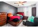 Well-lit bedroom with dark gray accent wall, a ceiling fan, and cozy decor at 9033 Aspen Hollow Pl, Riverview, FL 33578