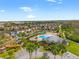 Community pool area featuring a clubhouse, playground, and well-manicured landscaping at 9033 Aspen Hollow Pl, Riverview, FL 33578