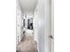 Hallway with gray walls, carpet floors, white doors, and views of the bedroom at the end at 9033 Aspen Hollow Pl, Riverview, FL 33578