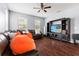 Bright living room with hardwood floors, large windows, and a modern entertainment center at 9033 Aspen Hollow Pl, Riverview, FL 33578
