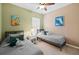 Bright bedroom featuring two twin beds, ceiling fan, and colorful decor on an accent wall at 9408 Greenpointe Dr, Tampa, FL 33626