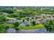 Expansive aerial view of homes with a pool and a scenic pond in a lush, green neighborhood at 9729 Asbel Estates St, Land O Lakes, FL 34638