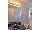 This bathroom showcases a vanity with a dark countertop and a large mirror with modern light fixtures at 9729 Asbel Estates St, Land O Lakes, FL 34638