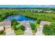 A beautiful aerial view of a landscaped home with a screened in pool with a serene lake backdrop at 9729 Asbel Estates St, Land O Lakes, FL 34638