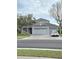 Charming home with a three car garage, lush landscaping, and a welcoming front porch at 9729 Asbel Estates St, Land O Lakes, FL 34638