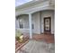 Inviting covered front porch with brick flooring, decorative columns, and charming details at 9729 Asbel Estates St, Land O Lakes, FL 34638