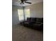 Cozy living room features plush carpeting, two windows and a comfortable sofa at 9729 Asbel Estates St, Land O Lakes, FL 34638