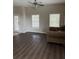 Living room features wood flooring and two windows providing natural light and a comfortable sofa at 9729 Asbel Estates St, Land O Lakes, FL 34638