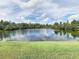 Scenic view of a tranquil pond surrounded by lush greenery and a clear sky at 9729 Asbel Estates St, Land O Lakes, FL 34638