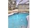 Inviting in-ground pool with clear blue water inside a screened enclosure and decorative tiling at 9729 Asbel Estates St, Land O Lakes, FL 34638