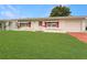 Charming single-story home with a well-maintained lawn, red accents, and attached garage at 9737 36Th N Way, Pinellas Park, FL 33782