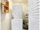 Efficient laundry room setup with a stacked washer and dryer and shelving for storage at 9737 36Th N Way, Pinellas Park, FL 33782
