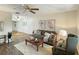 Inviting living room with wood floors, a ceiling fan, comfortable seating, and bright natural light at 9737 36Th N Way, Pinellas Park, FL 33782