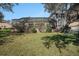 A spacious backyard with a screened-in pool and patio area, mature trees, and lush landscaping at 10129 Paddock Oaks Dr, Riverview, FL 33569
