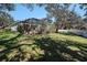 A large backyard featuring a screened-in pool, mature trees providing plenty of shade, and a lush lawn at 10129 Paddock Oaks Dr, Riverview, FL 33569