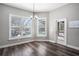 Bright breakfast nook featuring wood floors, neutral paint, modern light fixture, and views of the backyard pool area at 10129 Paddock Oaks Dr, Riverview, FL 33569