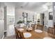 Dining area showcasing dark wood floors, neutral paint, elegant lighting, and seamless flow into kitchen at 10129 Paddock Oaks Dr, Riverview, FL 33569
