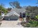 A beautifully landscaped home, showcasing a three-car garage and an inviting front entrance at 10129 Paddock Oaks Dr, Riverview, FL 33569