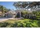 Charming single-story home featuring a three-car garage, brick driveway, and lush landscaped front yard at 10129 Paddock Oaks Dr, Riverview, FL 33569