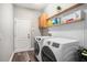 Laundry room with washer, dryer, shelving and wood look floors at 10129 Paddock Oaks Dr, Riverview, FL 33569