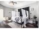 Luxurious main bedroom featuring a four-poster bed, plush rug, dark wood floors, and elegant decor at 10129 Paddock Oaks Dr, Riverview, FL 33569
