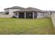 Large backyard with green grass and a screened-in patio, perfect for outdoor entertaining at 10812 Applewood Range Way, Tampa, FL 33647